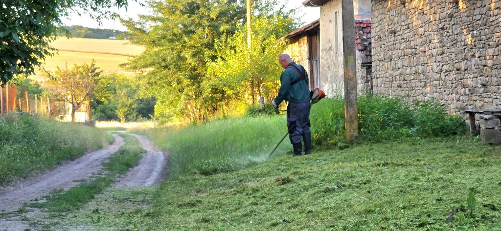 Landscaping worker maintaining a residential garden in Sofia, Bulgaria
